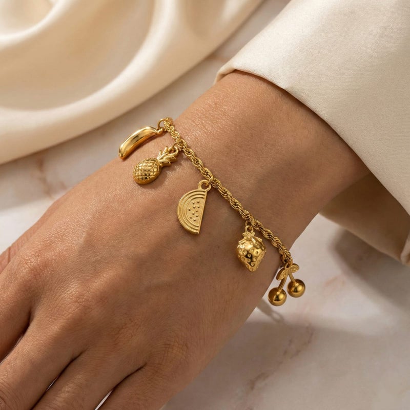 انسيال ذهبي أنيق مصنوع من الستانلس ستيل المقاوم للصدأ، يتميز بسلسلة مجدولة جذابة تزينها دلايات أشكال فواكه مبهجة، مع قفل قابل للتعديل ليناسبكِ. - Image 2